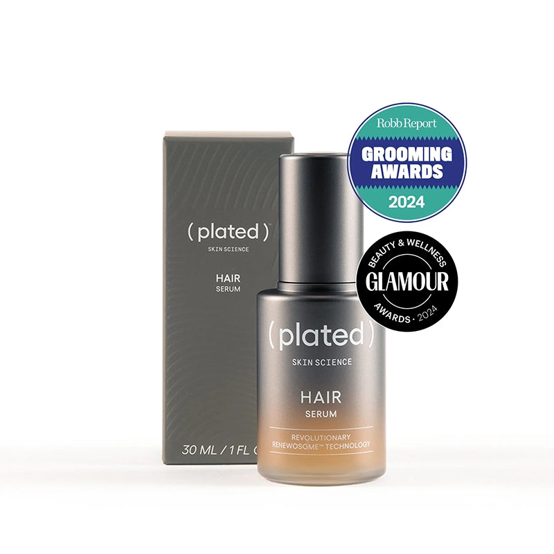 Plated hair serum bottle and box with awards on a white background
