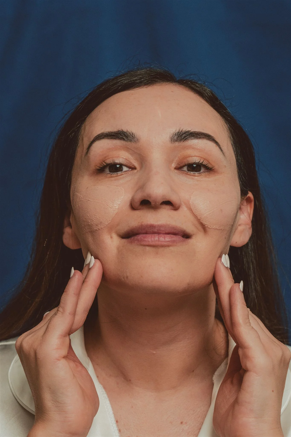 Dermasensa UV-X Mineral Sunscreen SPF 40 Lightly Tinted, 1.75oz tinted sunscreen being applied to the cheeks