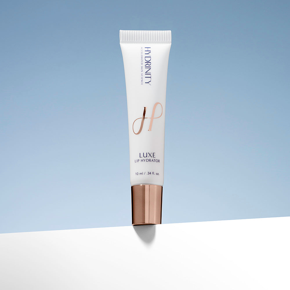 Tube of Hydrinity Luxe Lip Hydrator on a two toned background, 10ml/.34oz