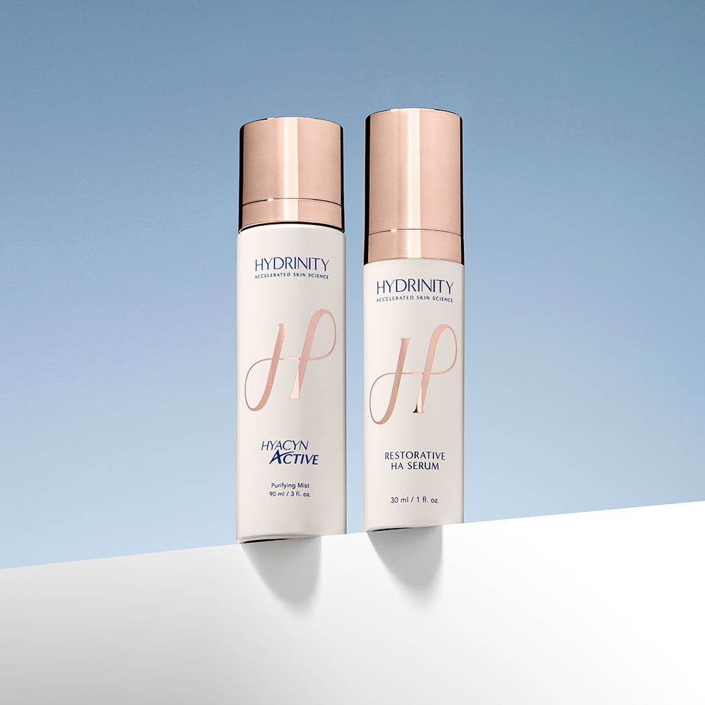 Two skincare bottles labeled 'Hydrinity' on a gradient blue background
